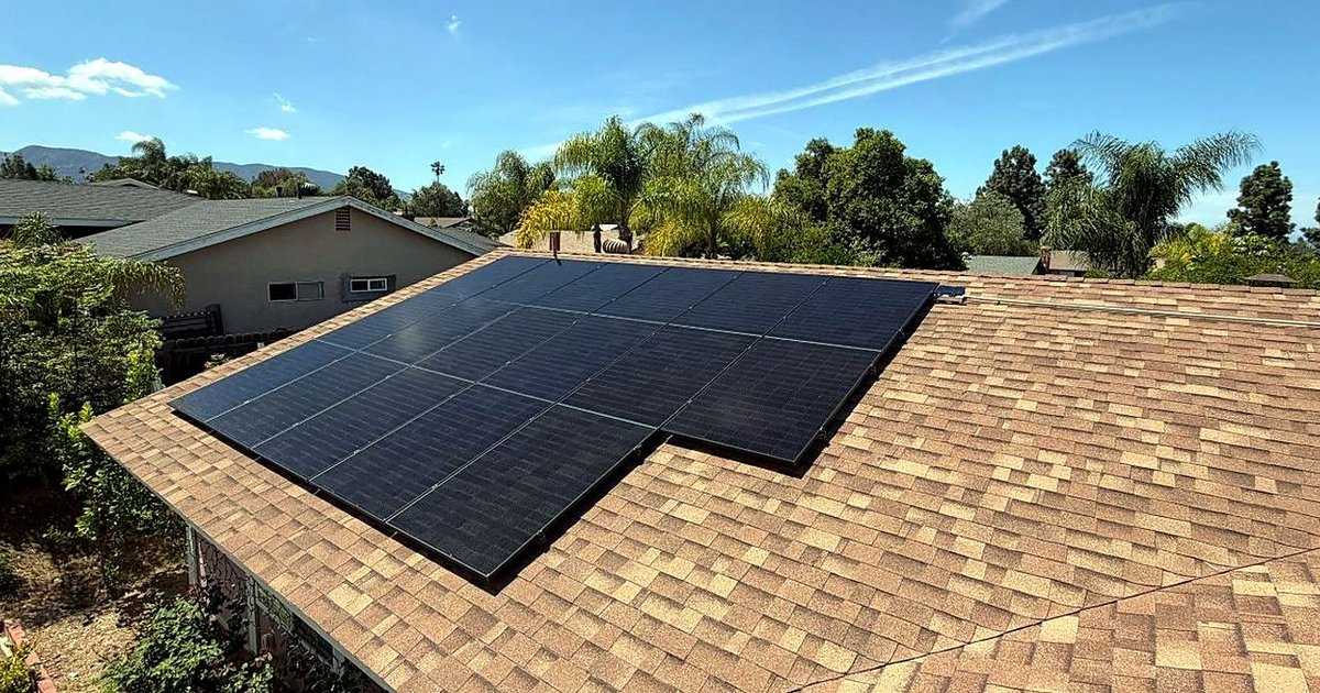Rooftop solar array on a San Fernando Valley-area home, with palms and foothills behind