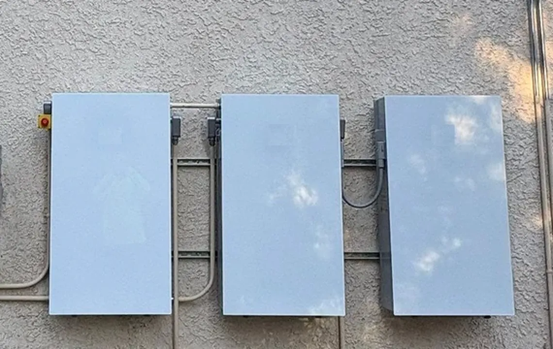Battery storage units mounted on an exterior wall by Current Energy