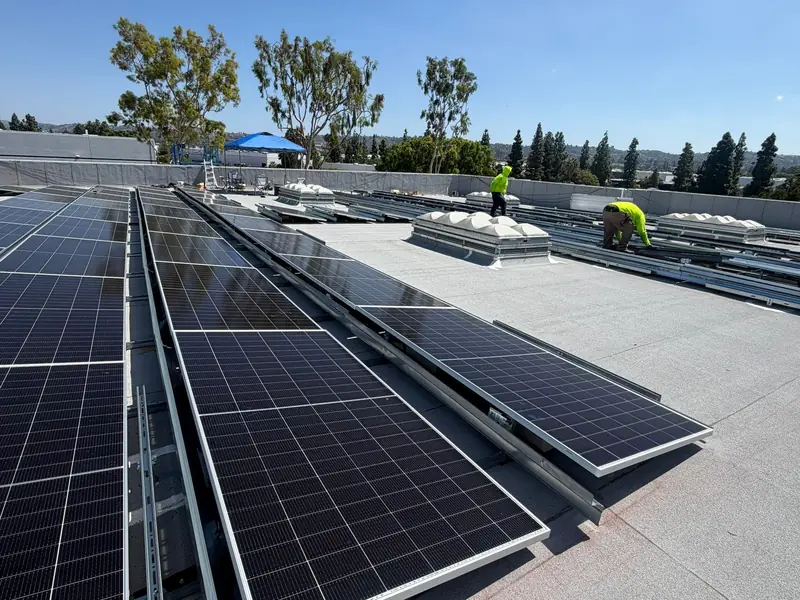 Tilted solar panel rows on a commercial warehouse roof installed by Current Energy