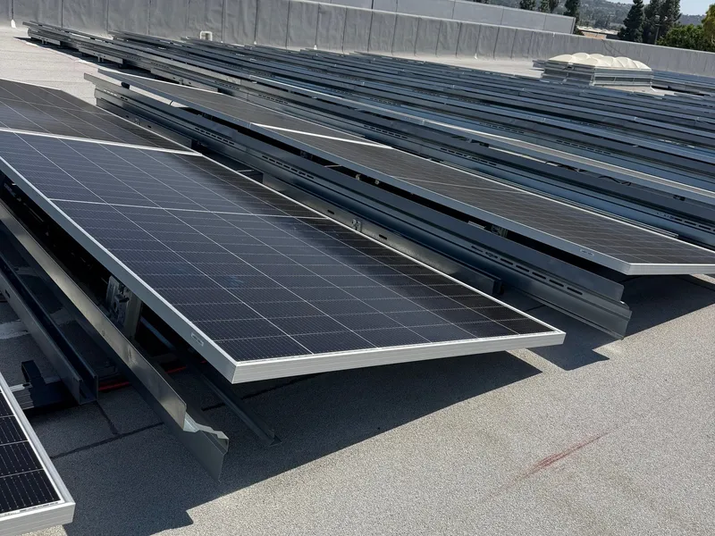 Tilted solar panel rows on a flat warehouse roof installed by Current Energy