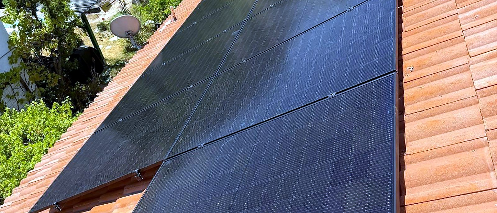 All-black solar modules on a red tile roof, installed by Current Energy