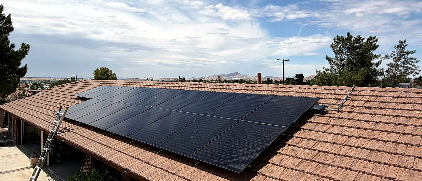 Tile roof with a solar array installed by Current Energy, foothills behind