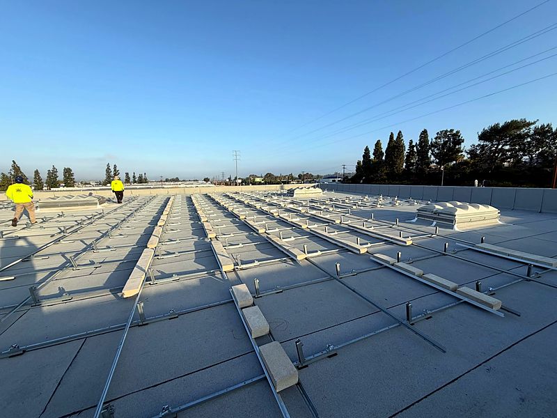 Current Energy crew laying out racking on a commercial roof at sunrise