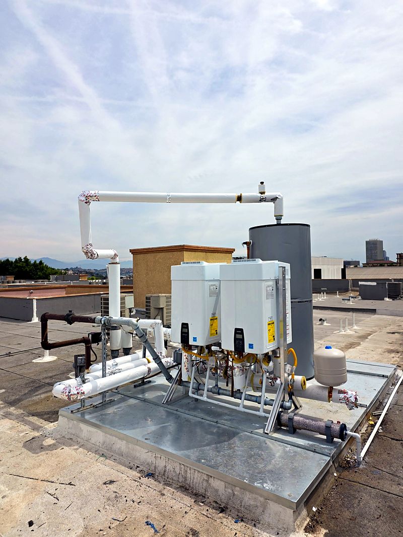 Rooftop tankless and storage water-heating plant at a multifamily building