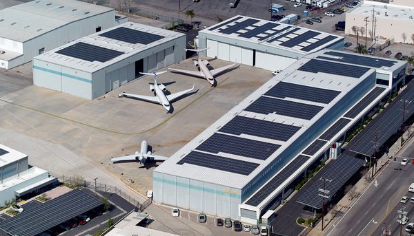 Solar hangar roofs with business jets parked on the apron at Van Nuys Airport
